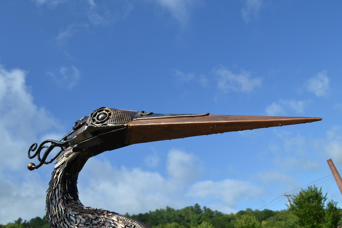 Heron sculpture beak against blue sky