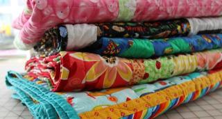 A close up photograph of a stack of colorful quilting material